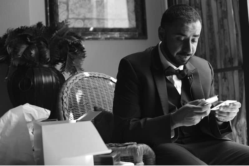 Photo of a Groom reading a letter from his bride